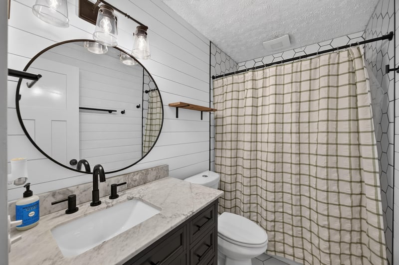 Bathroom vanity with granite top and plaid shower curtain at 6757 Deer Springs Rd, Keystone Heights, FL 32656