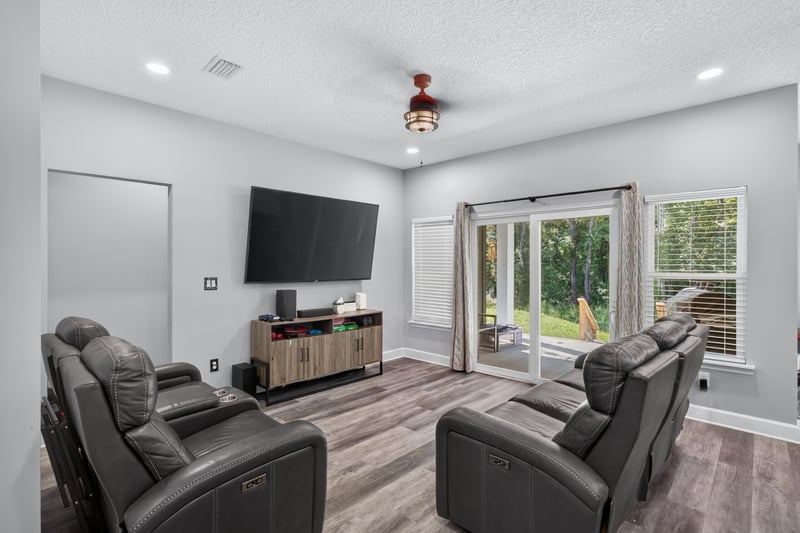 Living room with leather sectional and sliding glass doors at 2817 Camel Cir, Middleburg, FL