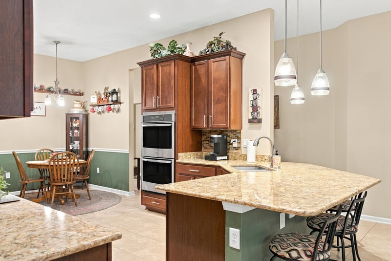 Kitchen with double wall ovens and dining table at 10923 Black Diamond Ct, Jacksonville, FL