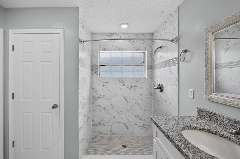 Bathroom with shower and window at 490 Hillside Dr, Orange Park, FL 32073
