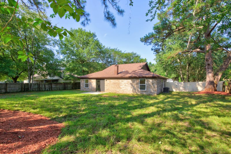 Backyard view of home exterior and lawn at 8453 Boysenberry Ln W, Jacksonville, FL
