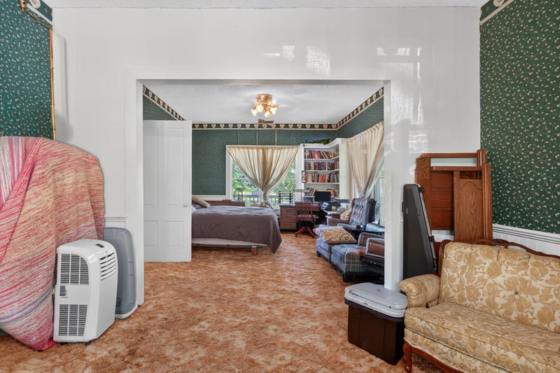 Bedroom with green wallpaper and window unit at 1173 US-17, Satsuma, FL 32189