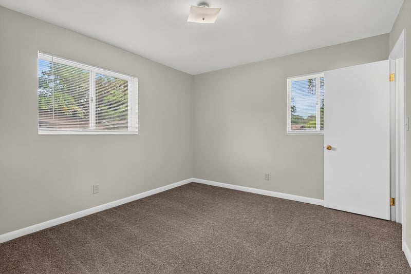 Carpeted bedroom with two windows at 2618 Arlex Dr E, Jacksonville, FL