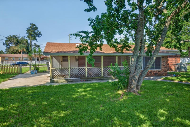 Backyard with lawn, trees and screened porch at 5503 Boeing Dr, Jacksonville, FL 32207