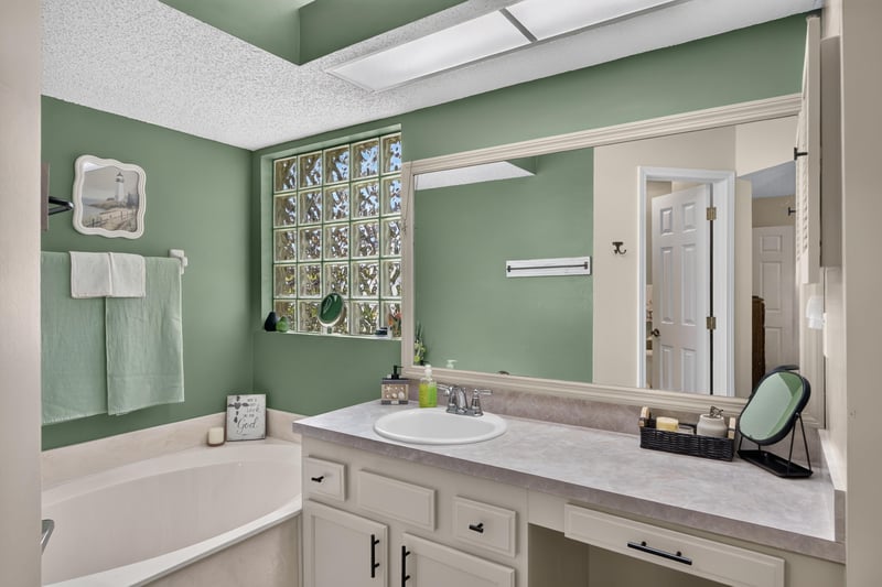 Primary bathroom with soaking tub and glass block window at 13514 Las Brisas Way N, Jacksonville, FL