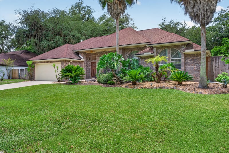 Side yard view of brick home at 12810 Swamp Owl Ln