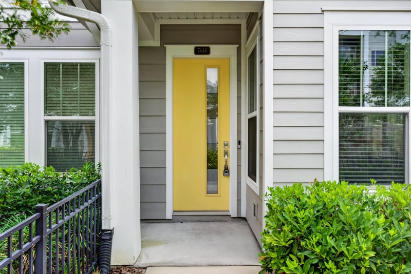 Front door detail with yellow paint and sidelight at 7446 Loggerhead Ct, Jacksonville, FL 32256
