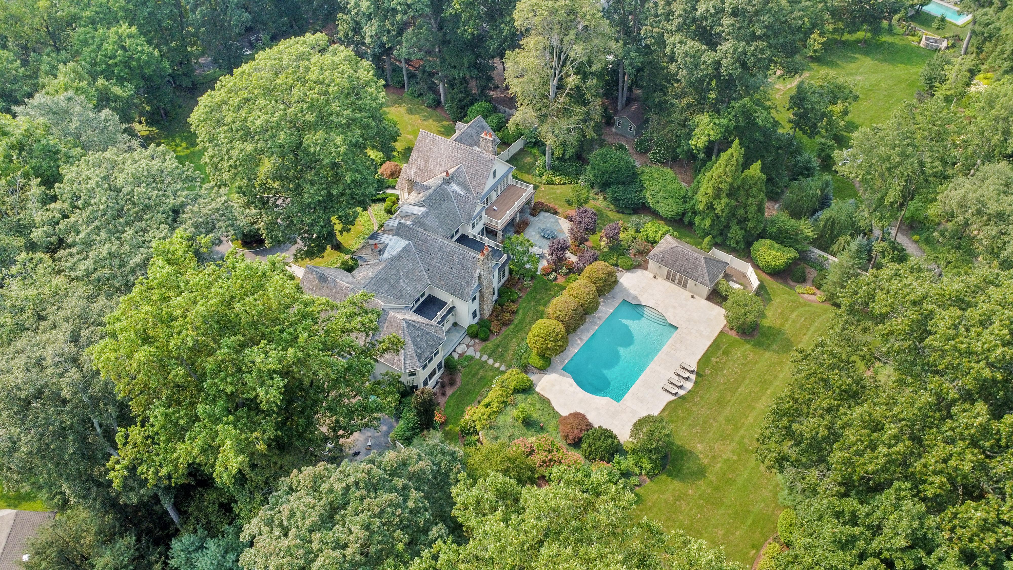 Aerial view showing a property's home, grounds, and swimming pool