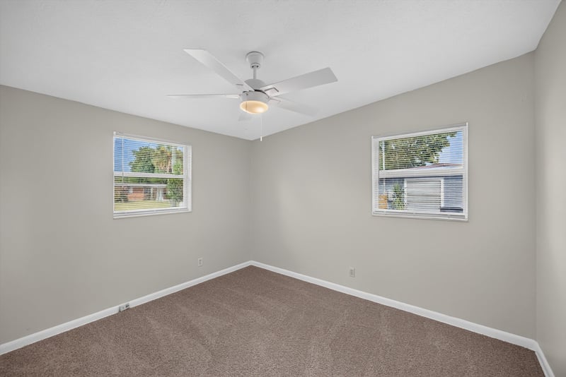 Carpeted bedroom with ceiling fan and window at 87 Saratoga Cir S, Atlantic Beach, FL