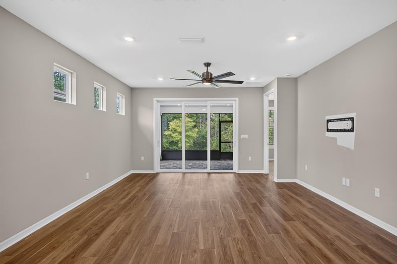 Living area with wood floors and sliding glass doors to the yard at 171 Oyster Shell Ter, Nocatee, FL 32081