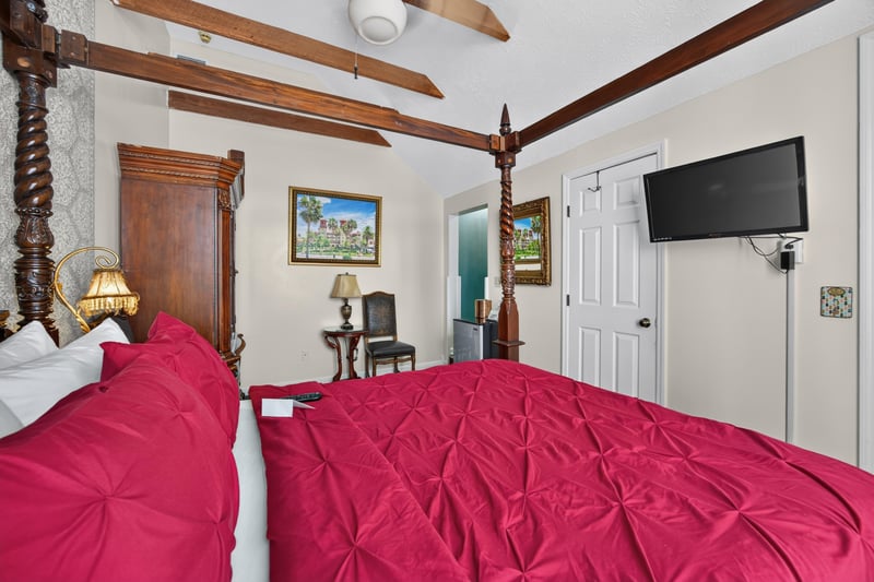 Bedroom with a four-poster bed under a wood beam ceiling at 115 Cordova St, St. Augustine, FL