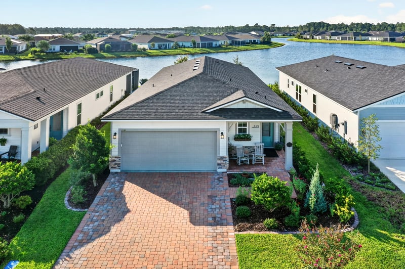 Day-to-dusk aerial close-up of the home's lakefront lot at 129 Amberwood Dr, St. Augustine, FL