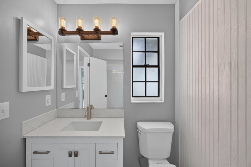 Bathroom vanity with four-light fixture and mirror at 6757 Deer Springs Rd, Keystone Heights, FL 32656