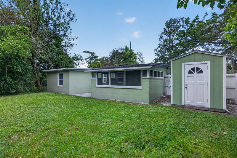 Backyard view with house, shed and open lawn at 2256 Inwood Cir S, Jacksonville, FL