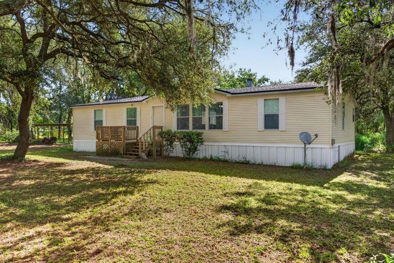Front exterior with covered porch and oak trees at 3215 Robin Ln, Middleburg, FL