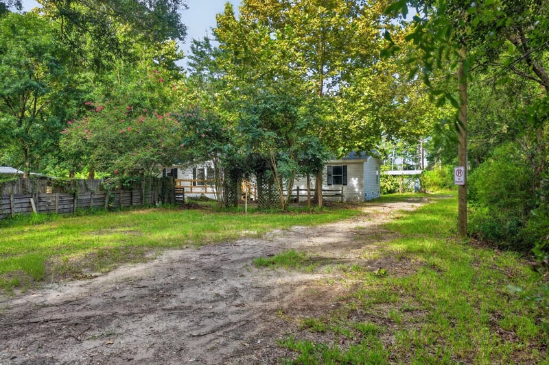 Dirt driveway winding through the wooded lot at 55520 Jewel-Thomas Rd, Callahan, FL 32011