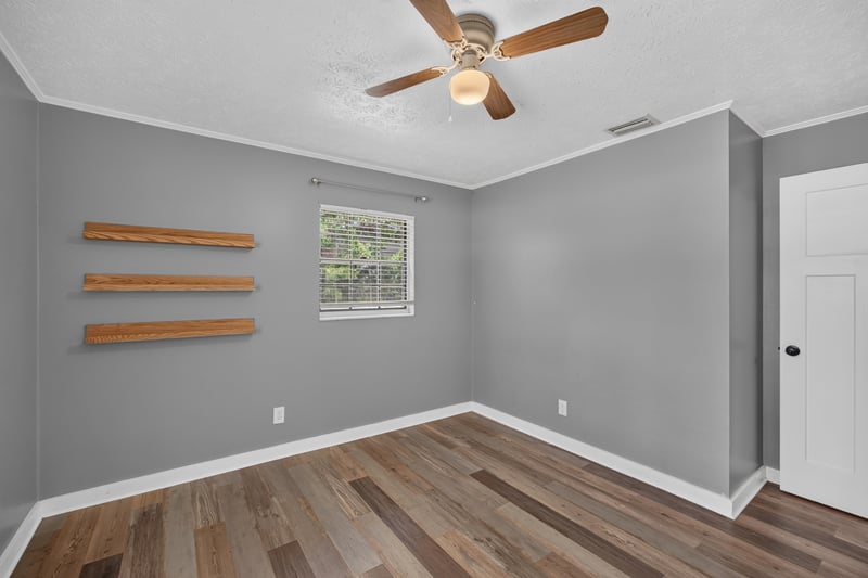 Bedroom with wall shelving and ceiling fan at 6757 Deer Springs Rd, Keystone Heights, FL 32656