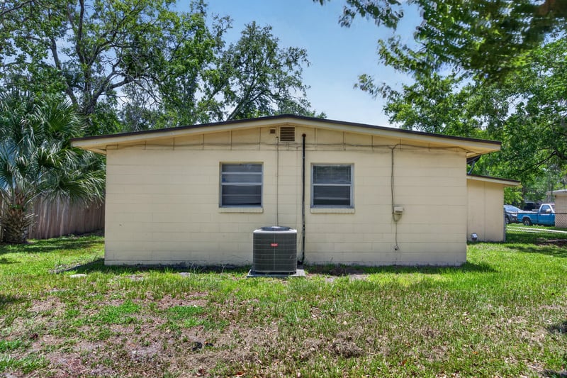 Rear exterior angle showing brick siding and yard at 5527 Beney Rd, Jacksonville, FL 32207