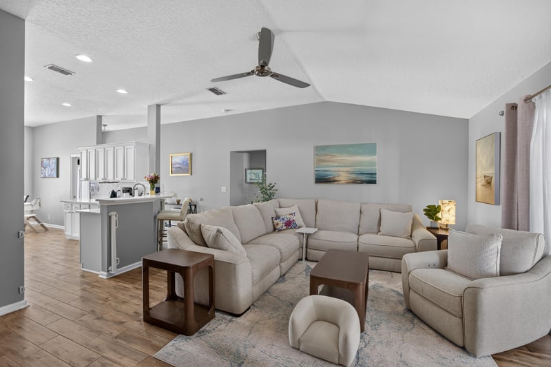Living room open to kitchen with ceiling fan at 12825 Kelsey Island Dr, Jacksonville, FL 32224