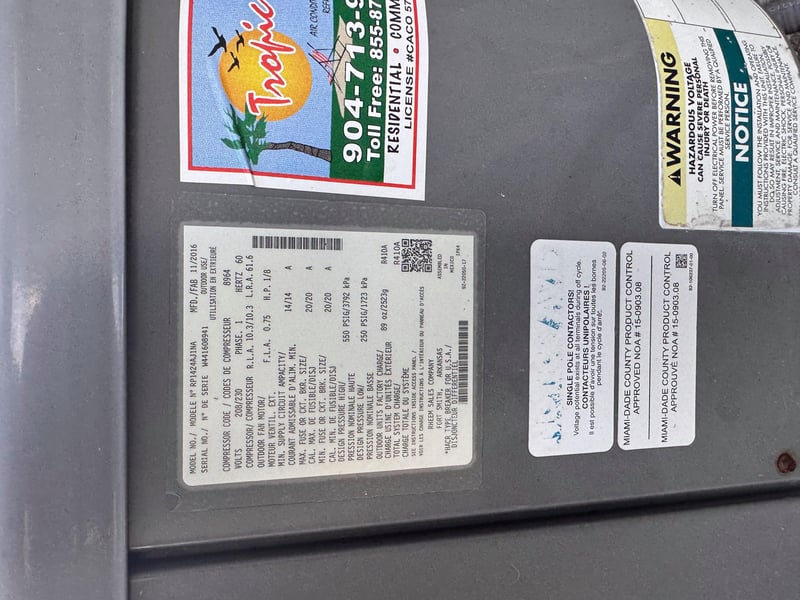 Condenser nameplate with multiple service stickers at 11700 New Kings Rd, Jacksonville, FL 32219