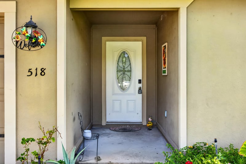 Front door with stained-glass window and address marker at 518 Matecumbe Ct, Macclenny, FL