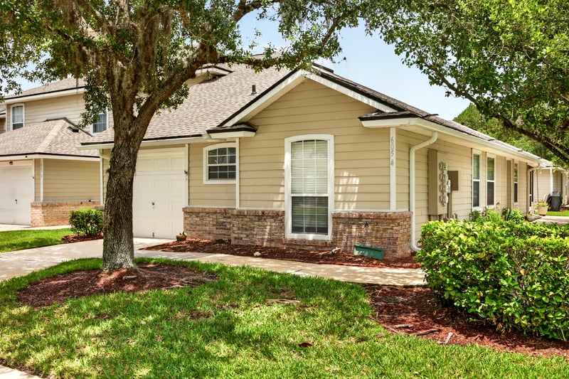 Front exterior with brick accent and landscaped lawn at 605 N Covered Bridge Rd, Jacksonville, FL