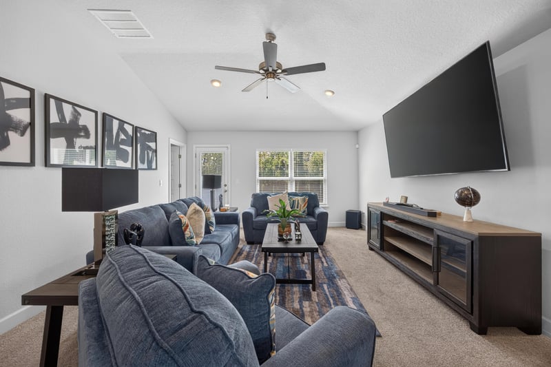Living room with sectional seating and ceiling fan at 9846 Olivia St, Jacksonville, FL