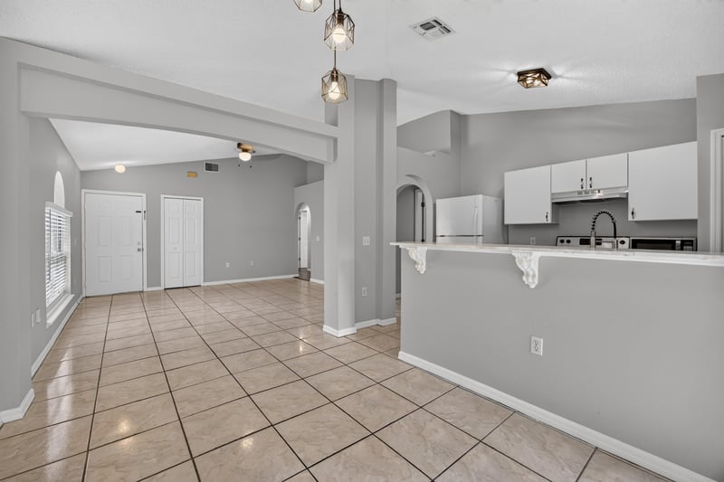 Open kitchen and living area with tile floor and columns at 7329 Lawn Tennis Ln, Jacksonville, FL