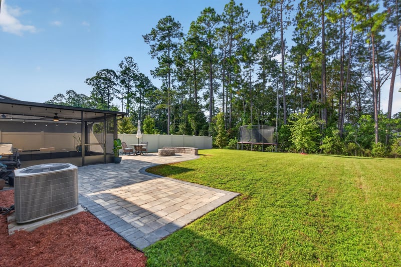 Backyard view with pergola and open lawn at 65255 Frst Glen Ln, Yulee, FL 32097