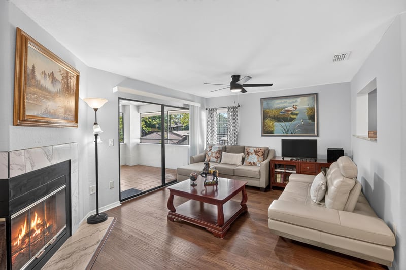 Living room with fireplace, sliding doors, and dining area at 10150 Belle Rive Blvd, Jacksonville, FL
