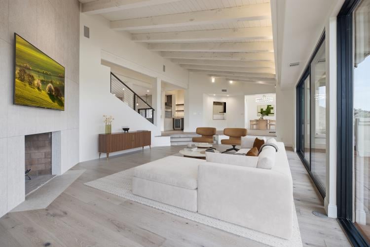 Open great room by the stairs, virtually staged