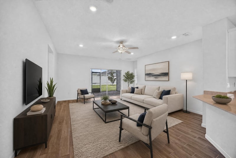 Living room with sofa and ceiling fan, virtually staged at 9905 Ansley Lake Dr, Jacksonville, FL