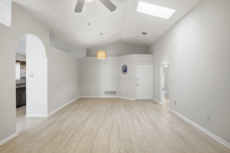 Living area with arched doorway and wood-look floors at 678 5th Ave N, Jacksonville Beach, FL 32250