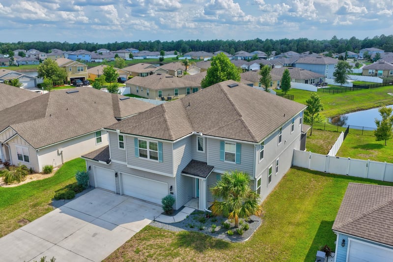 Aerial view of houses and pond under cloudy sky in Green Cove Springs, FL