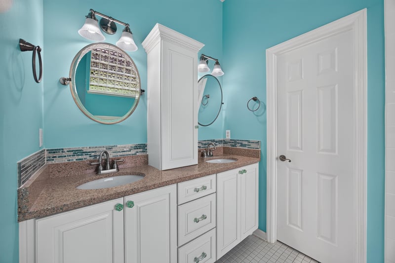 Primary bathroom with dual mirrors and teal walls at 1955 GUARDED Way, Fleming Island, FL 32003