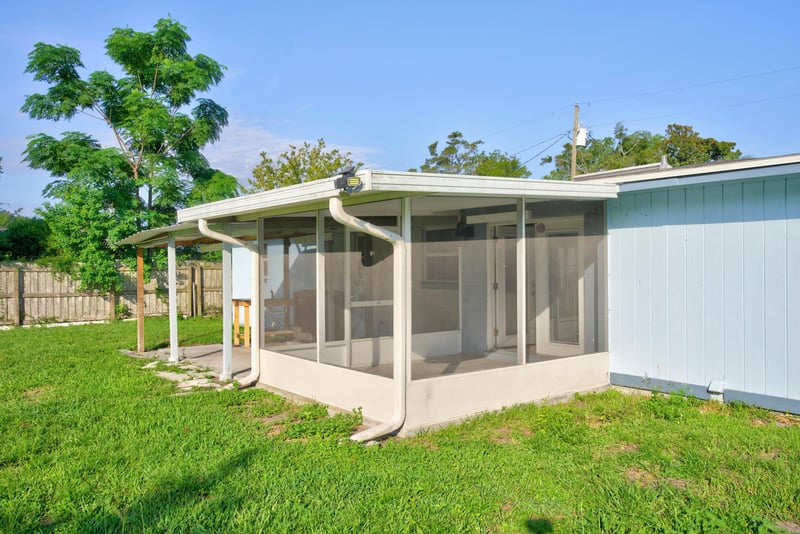 Screened porch and back exterior with green lawn at 442 Ameca Ave, Orange Park, FL 32073
