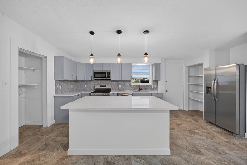 Kitchen island with pendant lights and stainless refrigerator at 3113 Kline Rd, Jacksonville, FL 32246