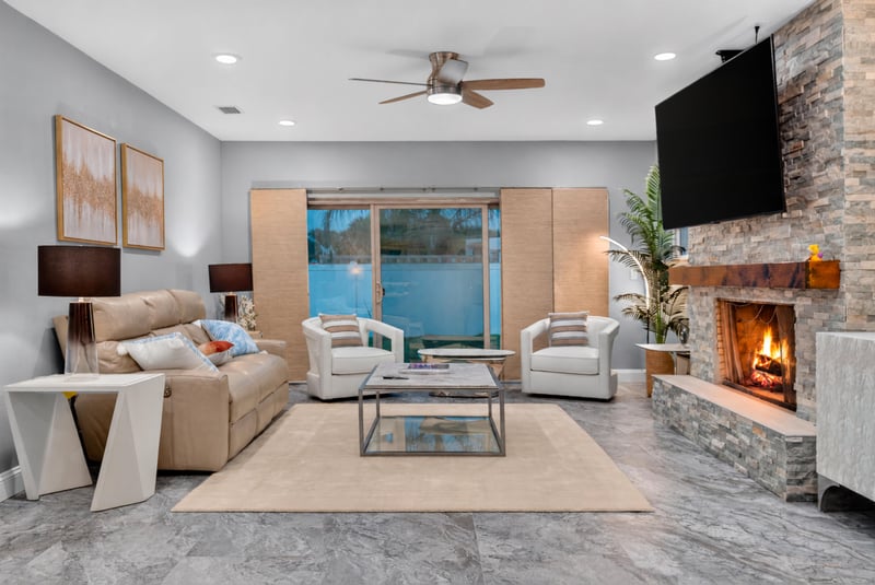 Living room with fireplace, TV and pool-view windows at 1525 8th St N, Jacksonville Beach, FL
