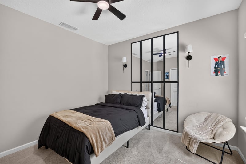 Bedroom with black-framed window and accent chair at 9942 Lovage Ln, Jacksonville, FL 32219
