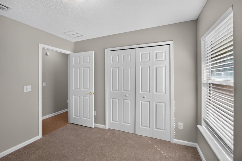 Carpeted bedroom with double closet doors at 14147 Fish Eagle Dr E, Jacksonville, FL 32226