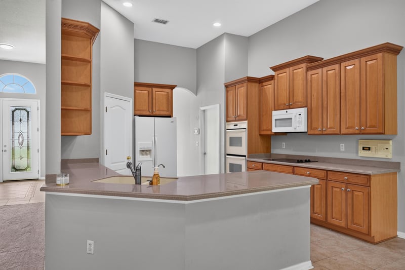 Kitchen island with wood cabinets and window at 635 Wakeview Dr, Orange Park, FL 32065