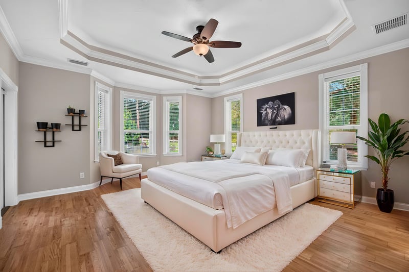 Primary bedroom staged with tray ceiling and windows at 1735 Hagans Ridge Ct