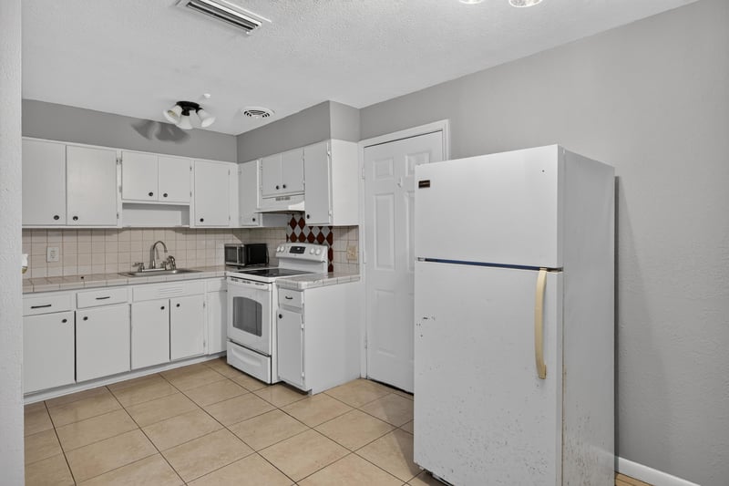 Kitchen view with refrigerator and tile backsplash at 4030 Leonard Cir W, Jacksonville, FL 32209