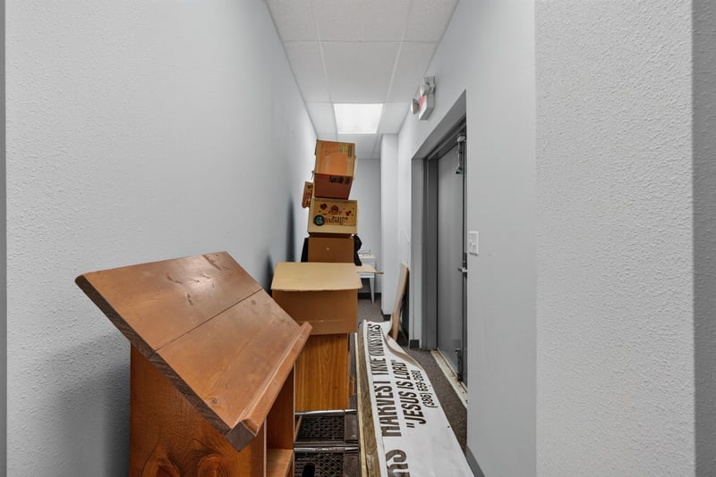 Hallway with stacked wood pews near exit door at 1038 County Rd 315, Melrose