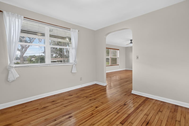 Dining area with wood floors and arched opening to kitchen at 217 Baisden Rd, Jacksonville, FL 32218