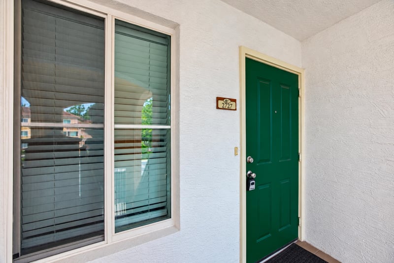 Green front entry door with adjacent sliding window at 9745 Touchton Rd, Jacksonville, FL 32246