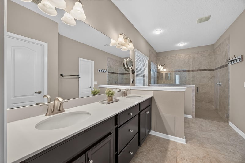 Primary bathroom double vanity with dark cabinets at 538 Porta Rosa Circle, St. Augustine, FL 32092