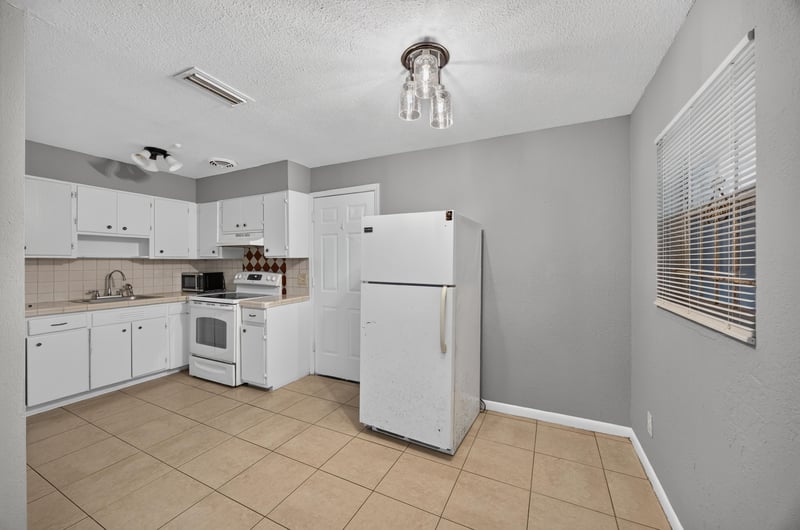 Kitchen with white cabinets and white appliances at 4030 Leonard Cir W, Jacksonville, FL 32209