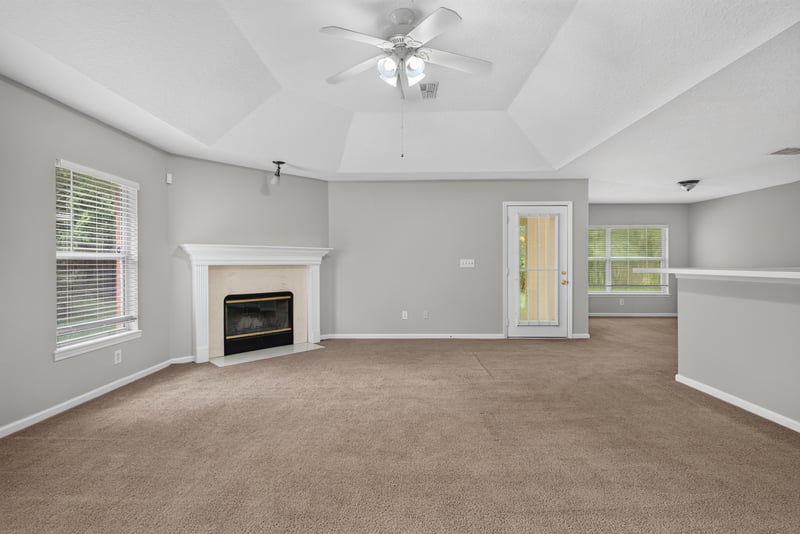 Living room with fireplace and tray ceiling at 11669 Collins Creek Dr, Jacksonville, FL 32258