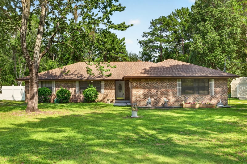 Front exterior of the brick ranch home and lawn at 2435 Range Line Rd, Middleburg, FL